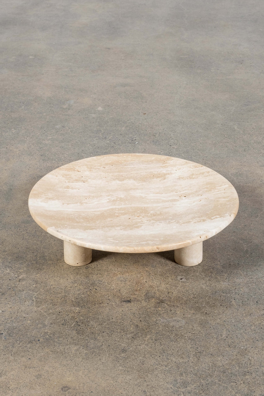 Round Footed Plate in Travertine, front angled view